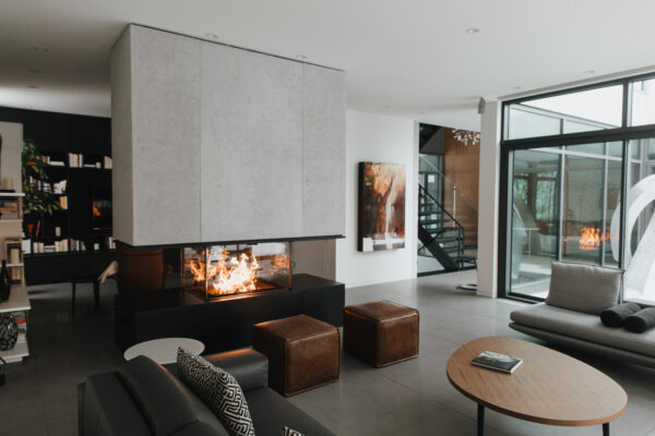 Modern living space with indoor fireplace and concrete cladding features.