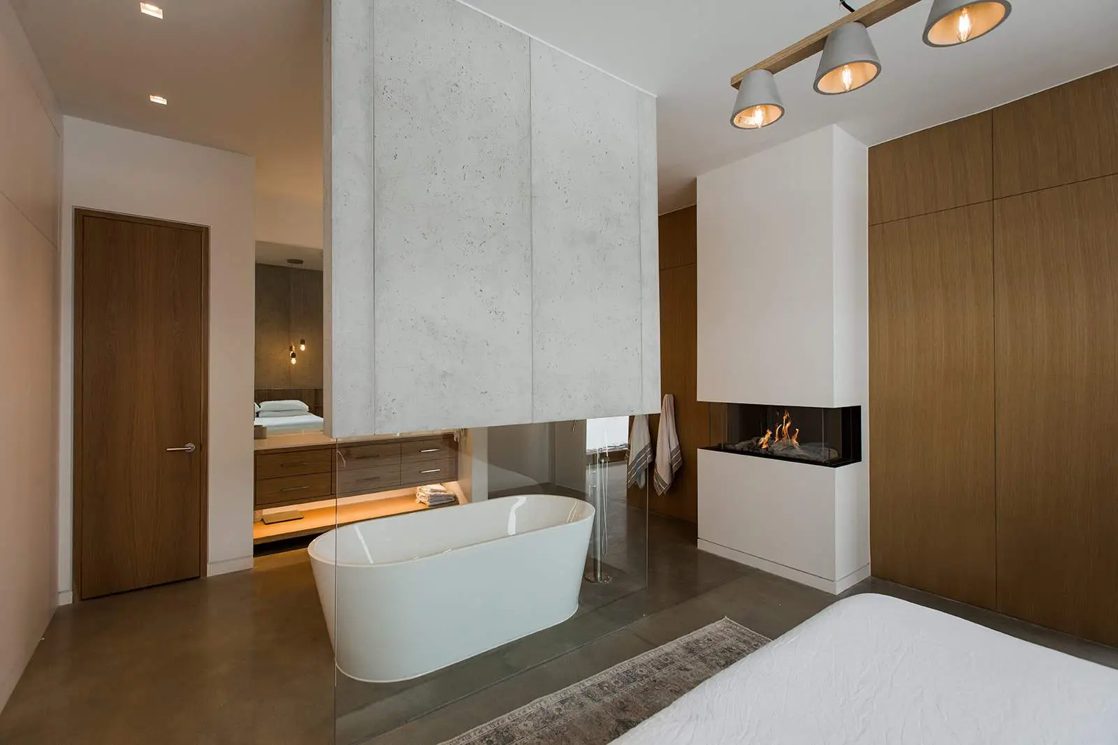 A floating concrete cladding wall in a bathroom with a fireplace concrete cladding wall by Dekko.