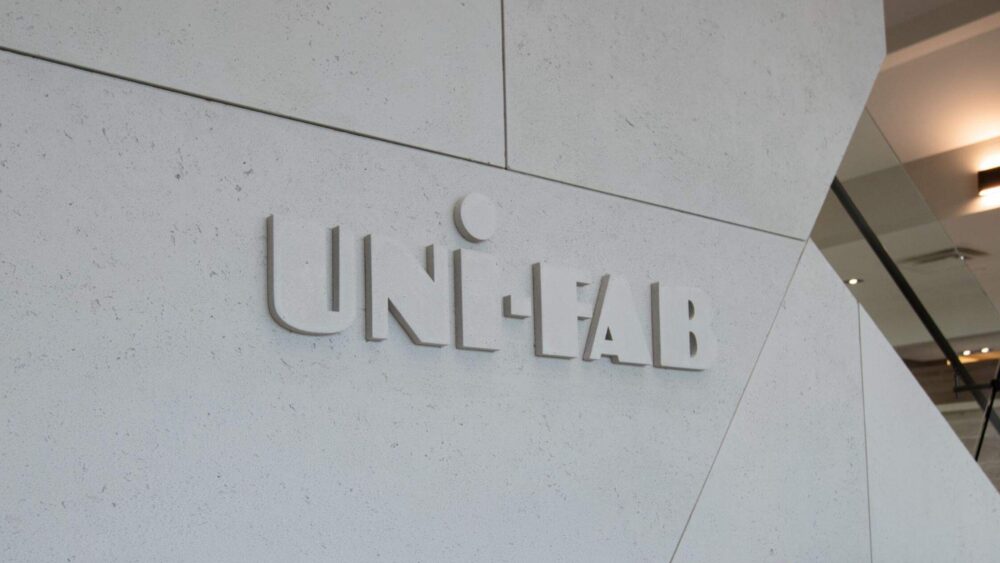 Entrance to office building with 'uni-fab' sign, featuring lightweight concrete cladding, industrial design and concrete feature logo.