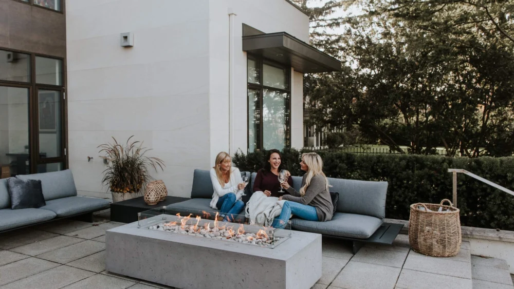 backyard gathering around concrete fire pit.